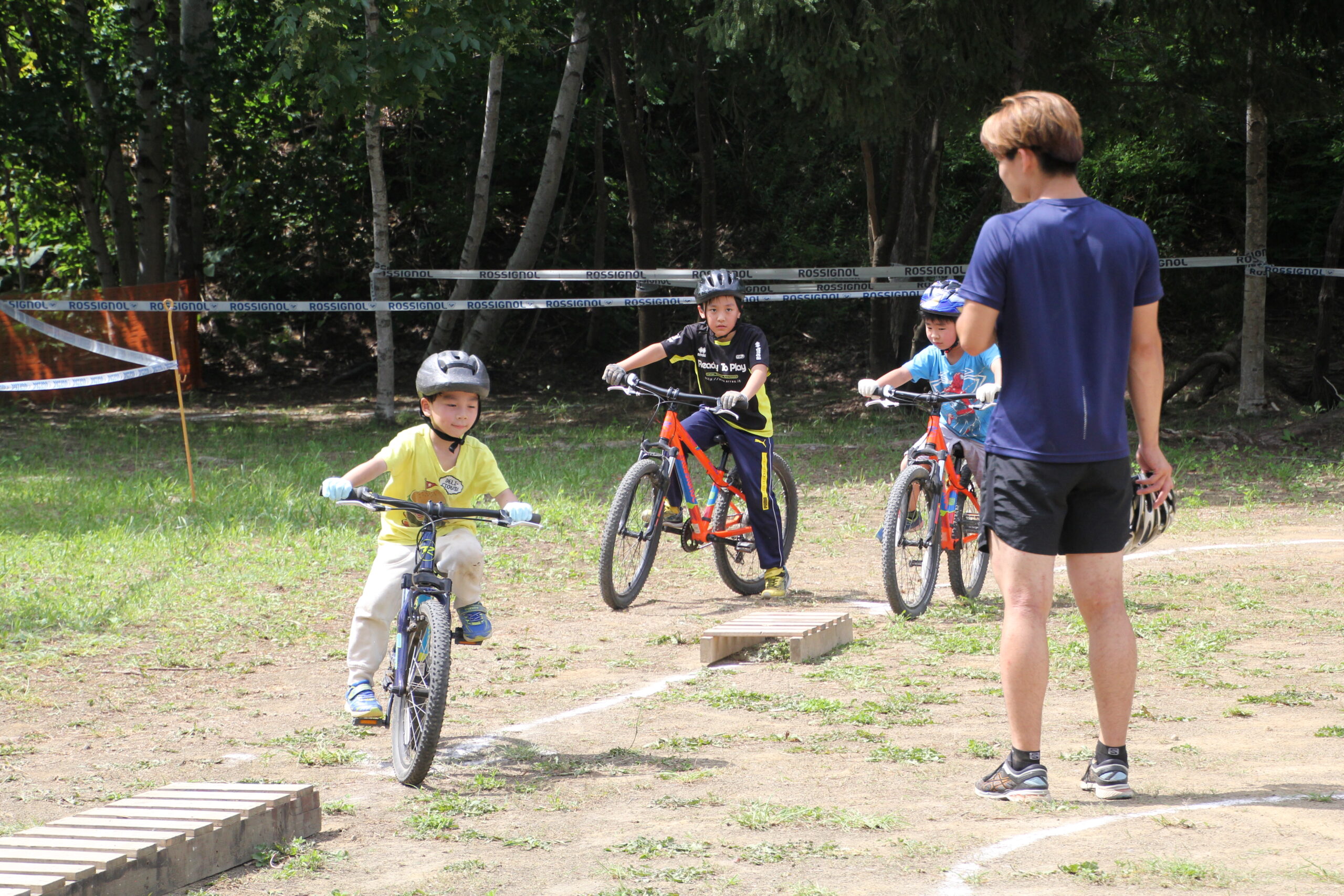 子どもたちが指導者と一緒にマウンテンバイク練習をしている様子